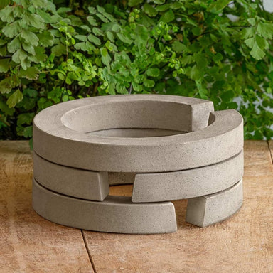 Guard Riser Round on table against green leaves.