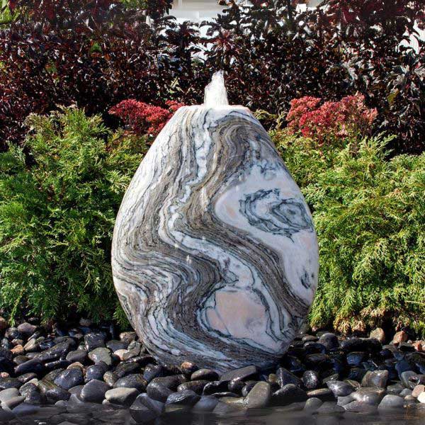 24 inch Pink Marble Almond Fountain Kit on black pebbles in the backyard