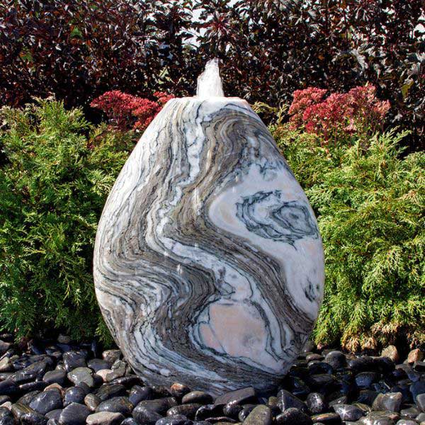 30 inch Pink Marble Almond Fountain Kit on black pebbles in the backyard