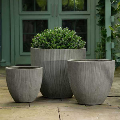 Airy Planter, Medium - Ash Grey Lite on concrete filled with plants