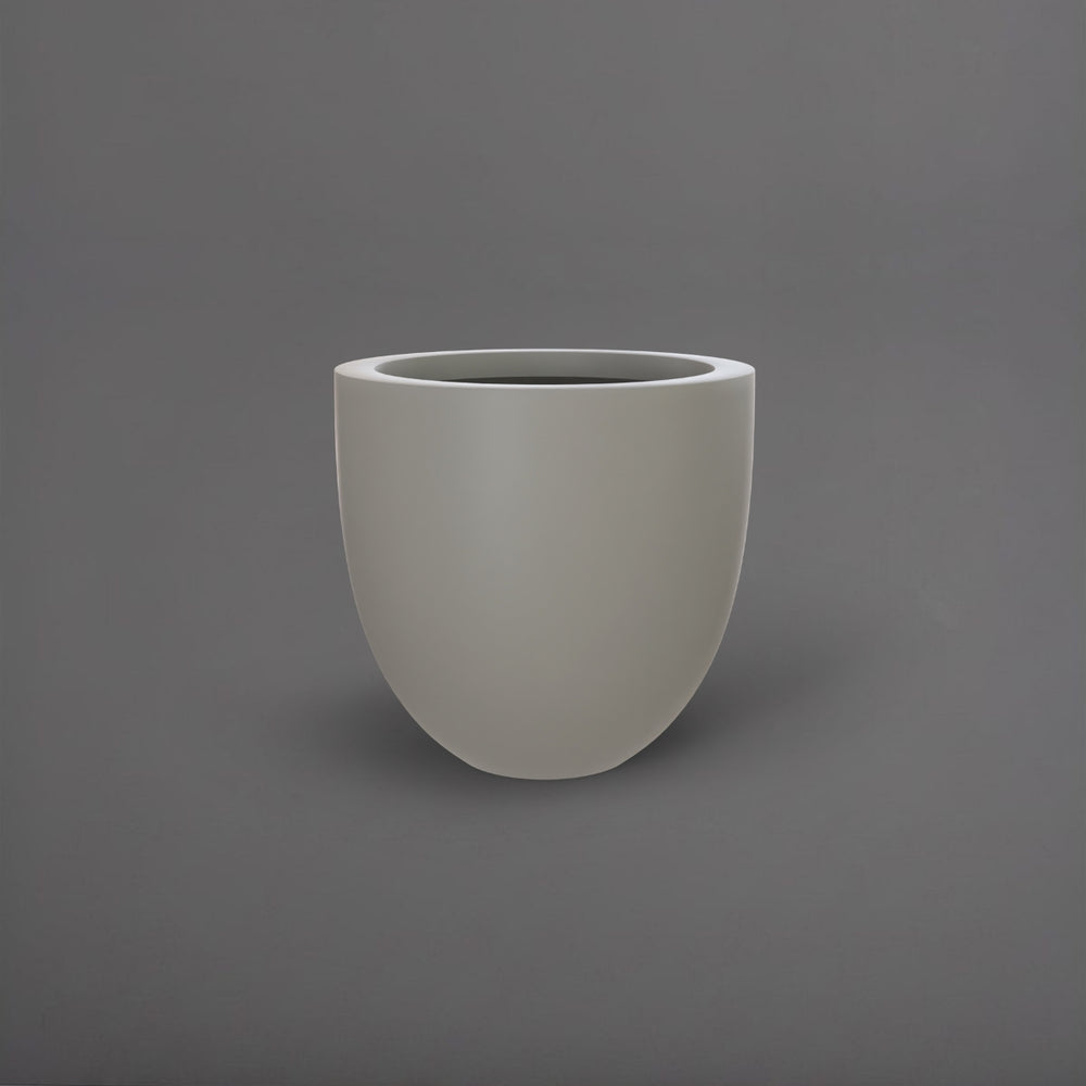 Alzira Round Fiberglass Planter in matte cement grey against gray background.