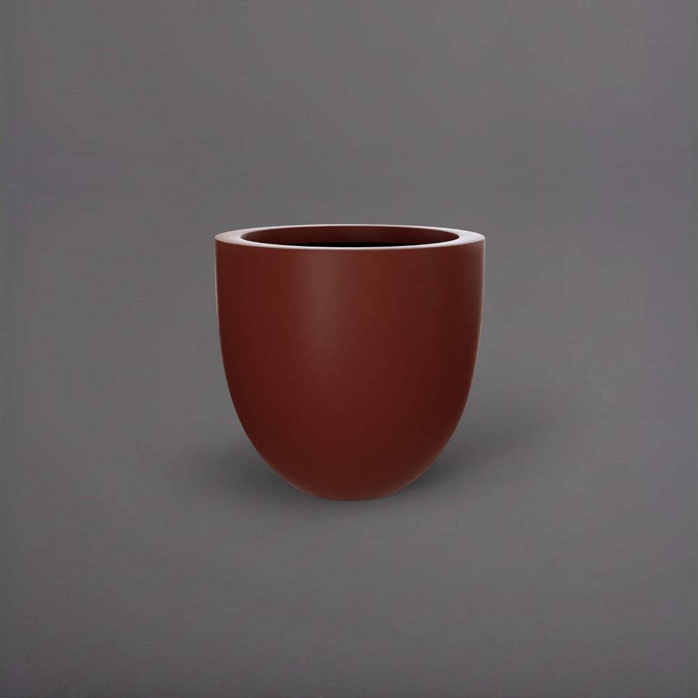 Alzira Round Fiberglass Planter in matte terra cotta against gray background.