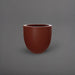 Alzira Round Fiberglass Planter in matte terra cotta against gray background.