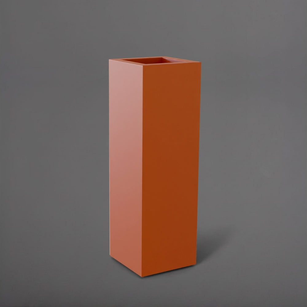 Amesbury Tall Corner Planter in matte terra cotta against gray background.