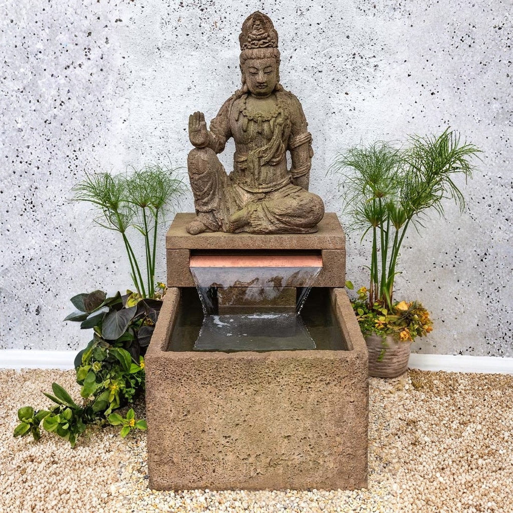 Antique Quan Yin Fountain on gravel in the backyard