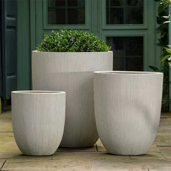 Arago Planter, Large - Alabaster Lite on concrete filled with plants