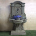 Arbois Wall Fountain on grass in the backyard.