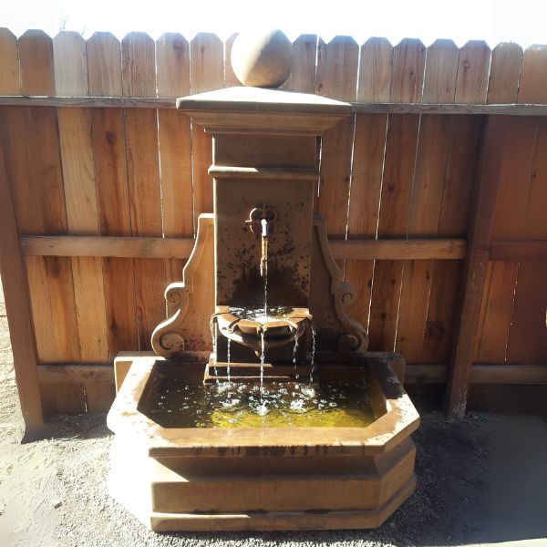 Avignon Wall Fountain in action against wooden fence. 