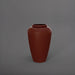 Bara Jar Tall Tapered Fiberglass Planter in matte terra cotta against gray background.
