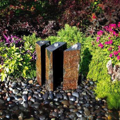 Basalt Fountain Kit 36 Triple Split Polished 3 piece on black pebbles in the backyard