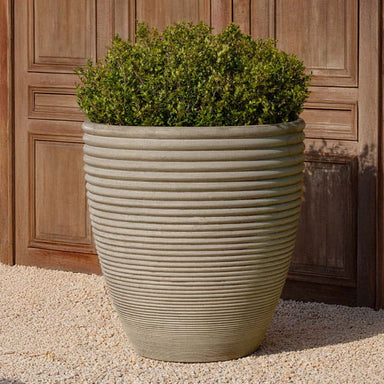 Bibendum Planter, Extra Large on gravel filled with plants.