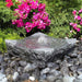 Bowled Zen Fountain on black peebles against pink flowers