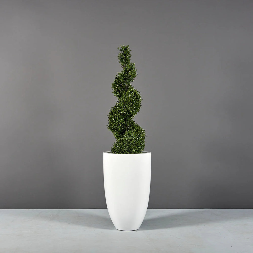 Brannan Tapered Round Fiberglass Planter on concrete filled with plants.