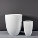 Brannan Tapered Round Fiberglass Planter on concrete shown with different sizes.