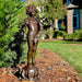 Bronze Boy with pipes on fish base fountain sculpture on ground in the backyard