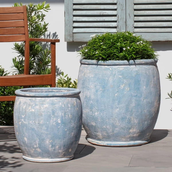 Brooke Planter in murano celeste color on concrete in the backyard.