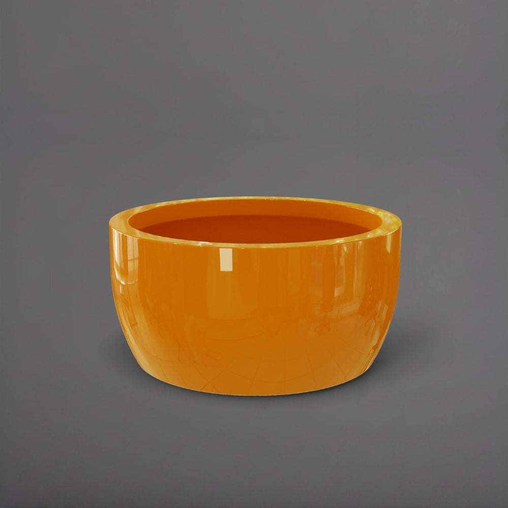 Casablanca Bowl Fiberglass Planter in gloss tangerine against gray background.