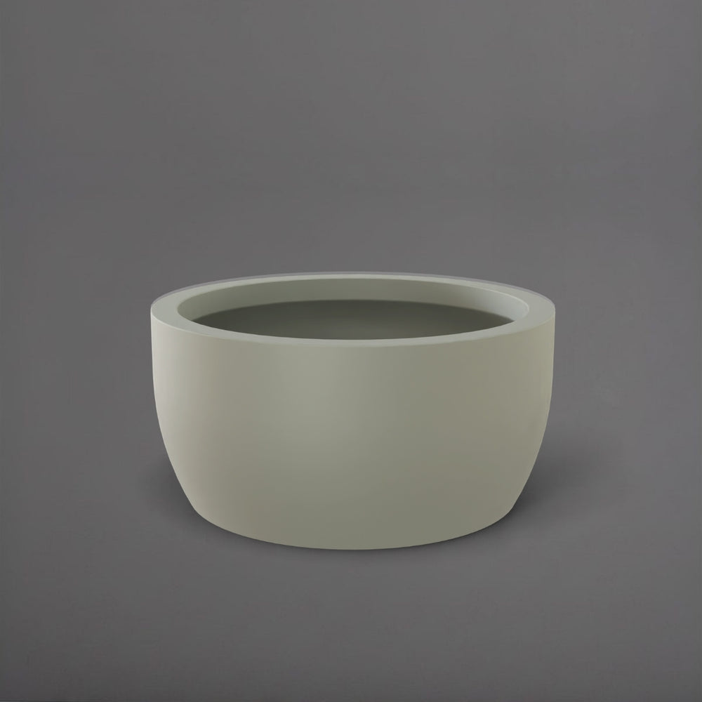 Casablanca Bowl Fiberglass Planter in satin beige against gray background.