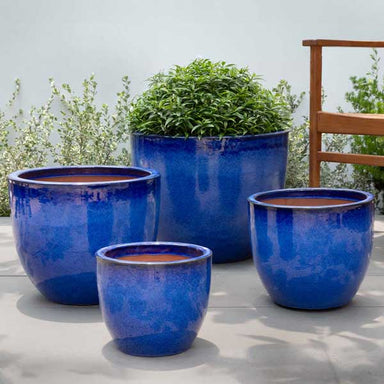 Cora Planter - Riviera Blue - S/4 on concrete filled with plants