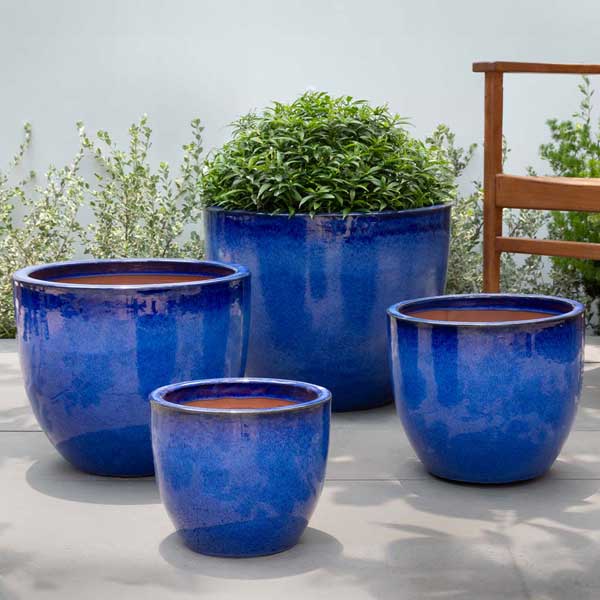 Cora Planter - Riviera Blue - S/4 on concrete filled with plants