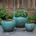 Coronado Planter - Antique Jade - S/3 on concrete filled with plants.