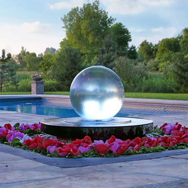 Crystal Sphere Fountain Kit beside pink flowers near a swimming pool