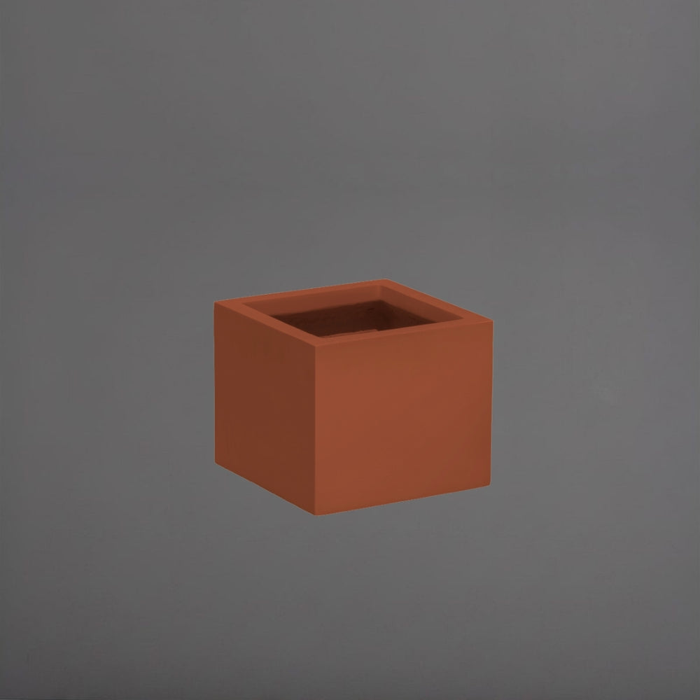 Cuba Low Corner Fiberglass Planter in matte terra cotta against gray background.