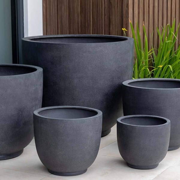 Danilo Planter, Extra Small in charcoal premium lite beside plants.