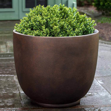 Danilo Planter, Extra Small in rust lite filled with plants.