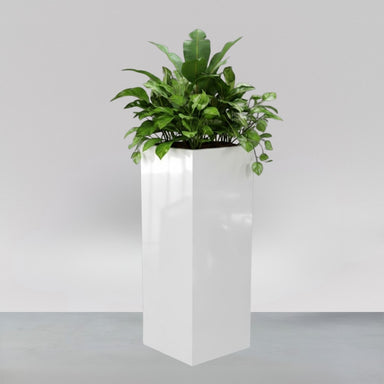 Delray Tall Corner Fiberglass Planter filled with plants against gray backdrop.
