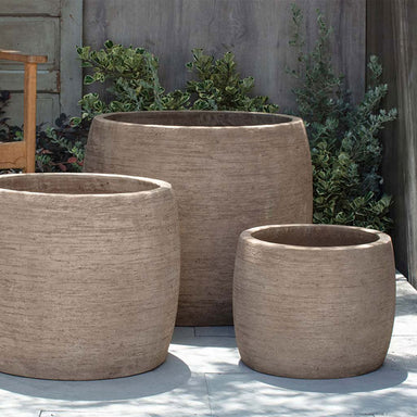 Denali Planter - Brown Terra Cotta - S/3 on concrete against green plants