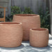 Denali Planter - Terra Cotta - S/3 on concrete against green plants