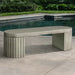 Dorchester Fluted Bench on concrete near a swimming pool.