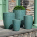 Falling Petals Planter, Tall filled with plants on patio.