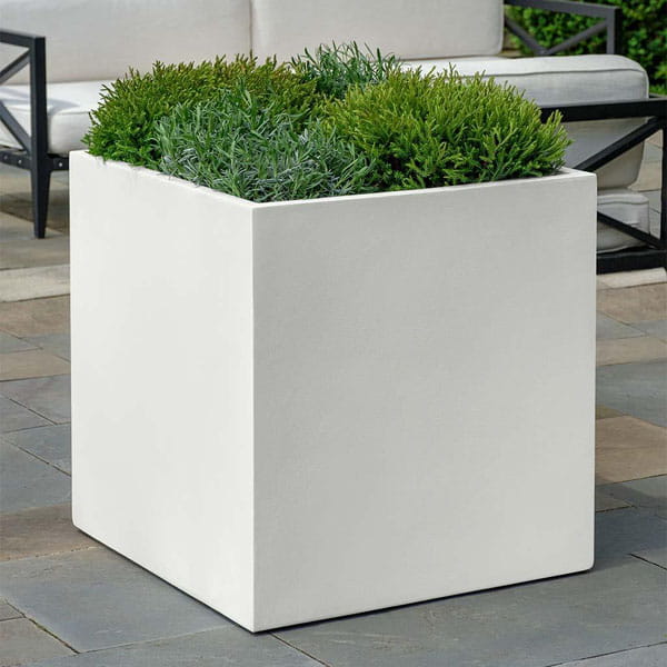 Farnley Planter 2424 S/1 in chalk lite on concrete filled with plants.