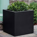 Farnley Planter 3636 S/1 in onyx black lite on concrete filled with plants.