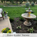 Fontana Grande outdoor fountain beside a backyard patio deck with garden landscaping at dusk.