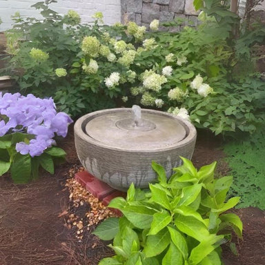 Girona Fountain in action in the backyard against plants