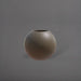 Globe Fiberglass Planter in matte bronze against gray background.