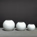 Globe Fiberglass Planter on concrete on concrete shown with different sizes.
