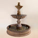 Grandis Calanthia Two Tier Pond Fountain against brown background.