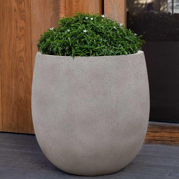 Guilford Planter, Large in stone grey lite on concrete filled with plants.