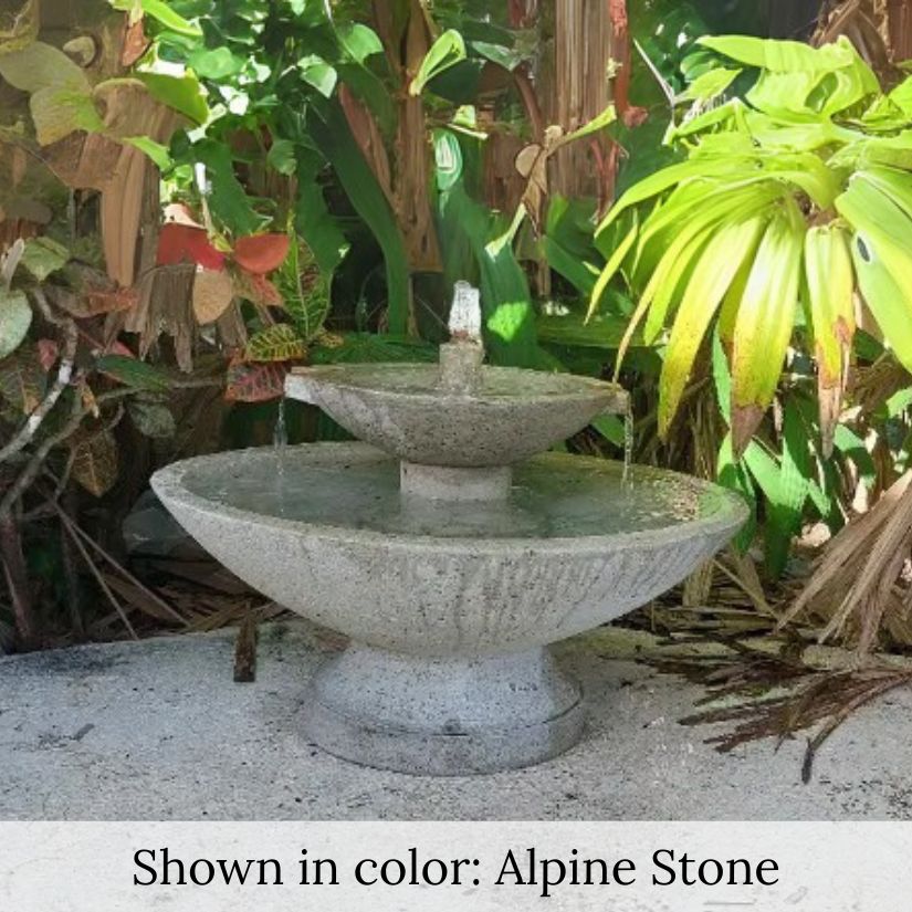 Jensen Oval Fountain on concrete against green plants. 