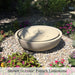 Large Girona Fountain in rock garden surrounded by flowers.