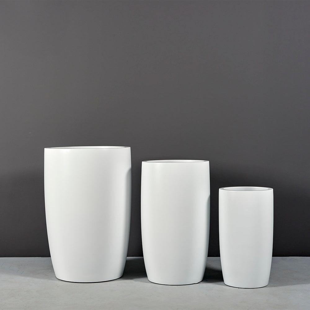 Lisbon Tall Round Tapered Fiberglass Planter on concrete shown with different sizes.