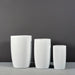 Lisbon Tall Round Tapered Fiberglass Planter on concrete shown with different sizes.