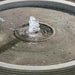Longitude Fountain on gravel in the backyard upclose.