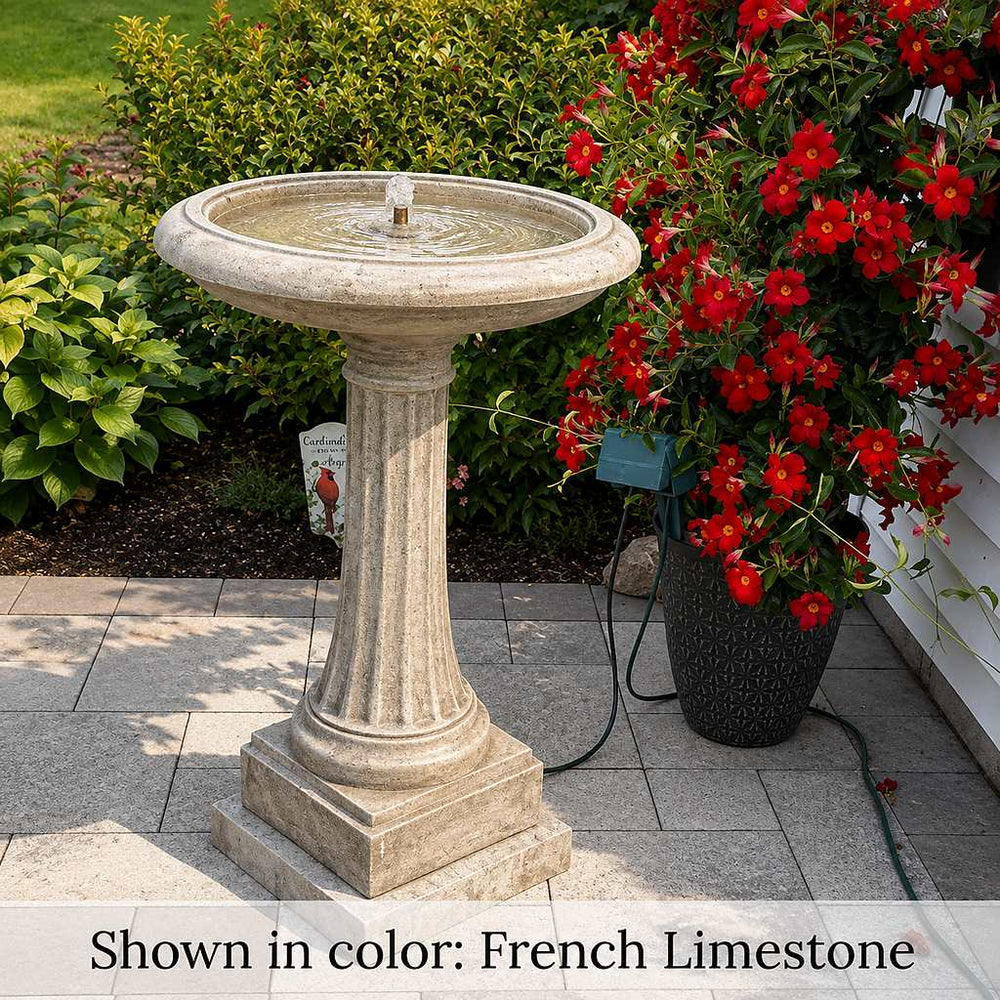 Longmeadow Fountain beside planter with red flowers.