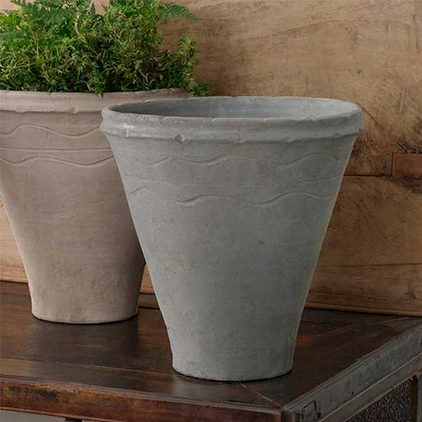 Matera Planter - Grey on table beside planter filled with plants