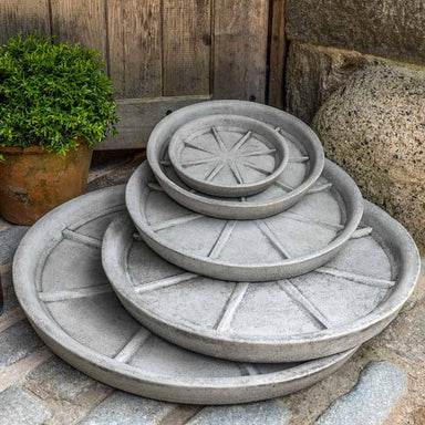 Medium Campania Plant Saucers on concrete in the backyard.